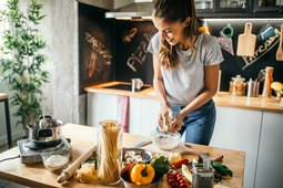 Young woman in the kitchen cooking with healthy alternatives