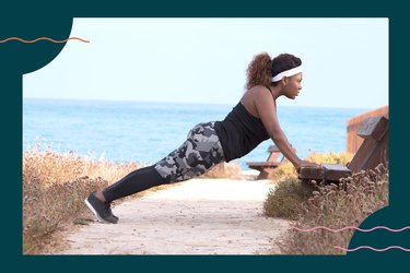a person wearing a black tank top, patterned leggings and black sneakers does an incline push-up on a bench at the beach as part of a 30-day push-up challenge