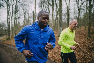 two middle-aged male runners going for a run in the woods