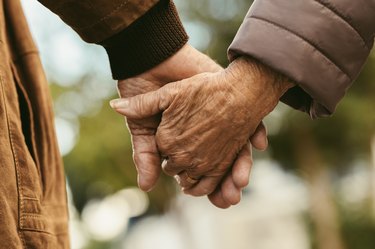 Elderly couple holding hands and in a happy relationship, as an example of healthy aging habits