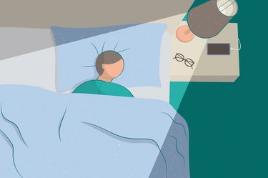 an illustration of a person sleeping in bed with their bedside lamp on
