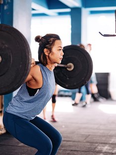 woman doing barbell squat for best lower-body workout
