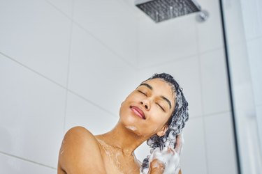 a woman washing her hair in the shower
