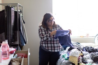 Hispanic Woman Folding Laundry at Home