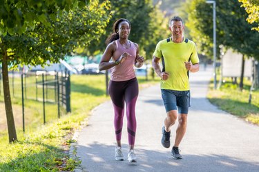 Two people running on a path in a park doing Fartlek training.